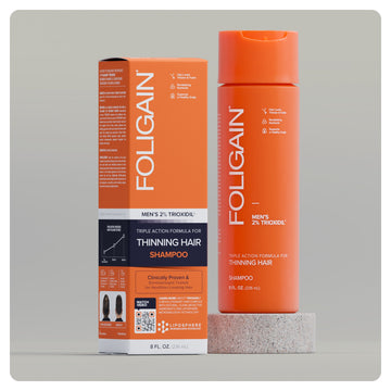 شامبو FOLIGAIN ثلاثي المفعول للرجال بتركيز 2% من TRIOXIDIL، عبوة برتقالية وعلبة.