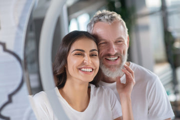 امرأة مبتسمة ورجل ذو شعر أشيب يقفان متقاربين.