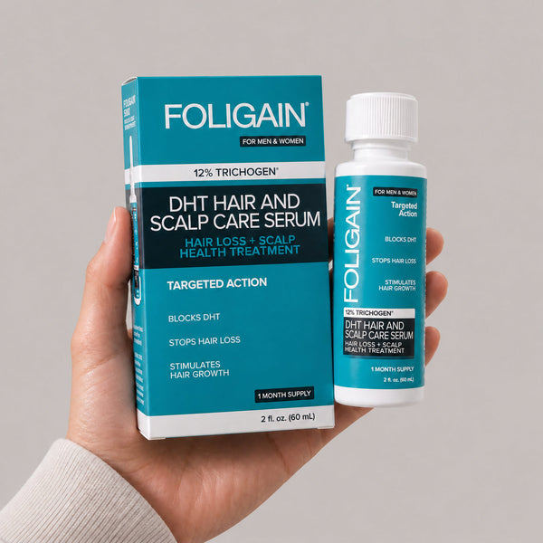 يد تحمل زجاجة وعلبة سيروم FOLIGAIN DHT للعناية بالشعر وفروة الرأس، بحجم 60 mL.