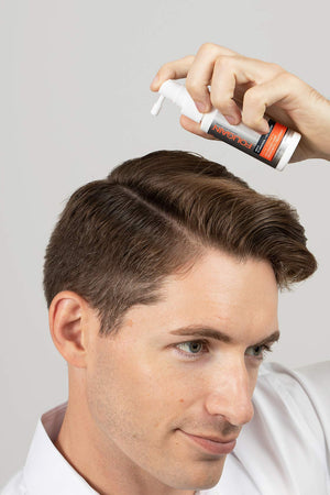 رجل يضع مينوكسيديل FOLIGAIN مباشرة على فروة رأسه
